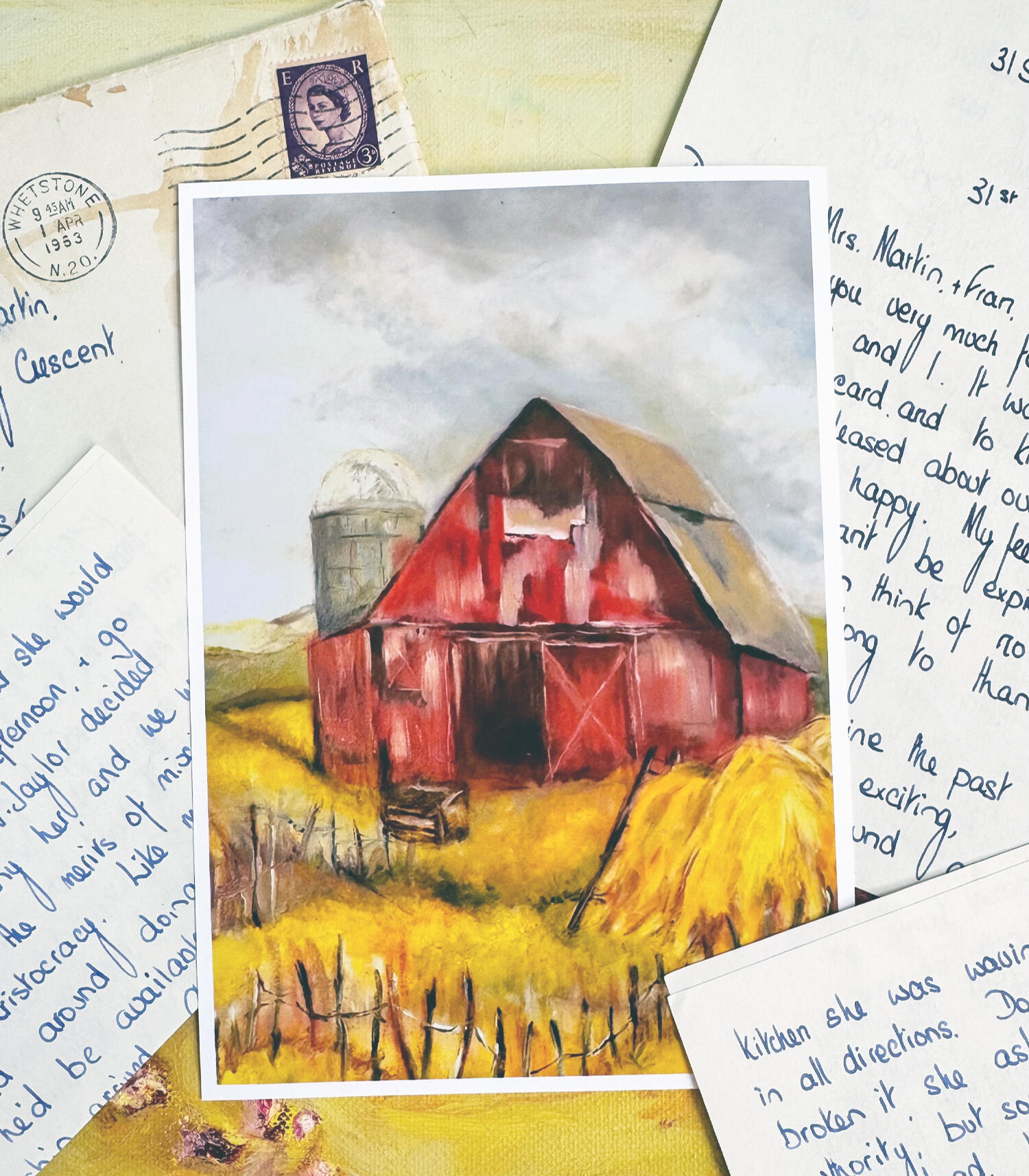 image of a collection of handwritten letters with an art print of a red barn and bales of hay.
